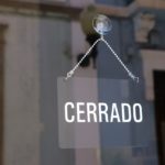 Puerta de comercio con cartel de cerrado